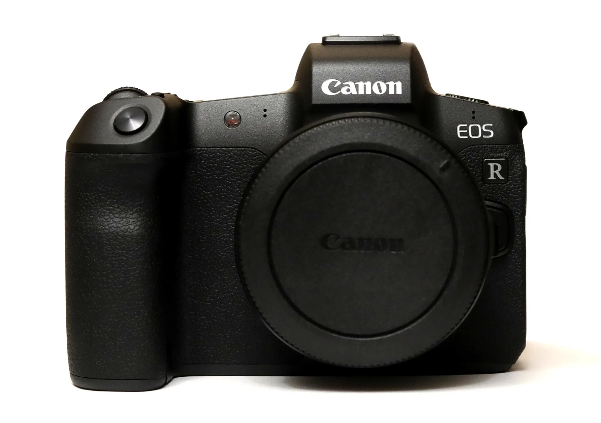 A black Canon EOS R body with its body cap fitted, seen from the front on a white background