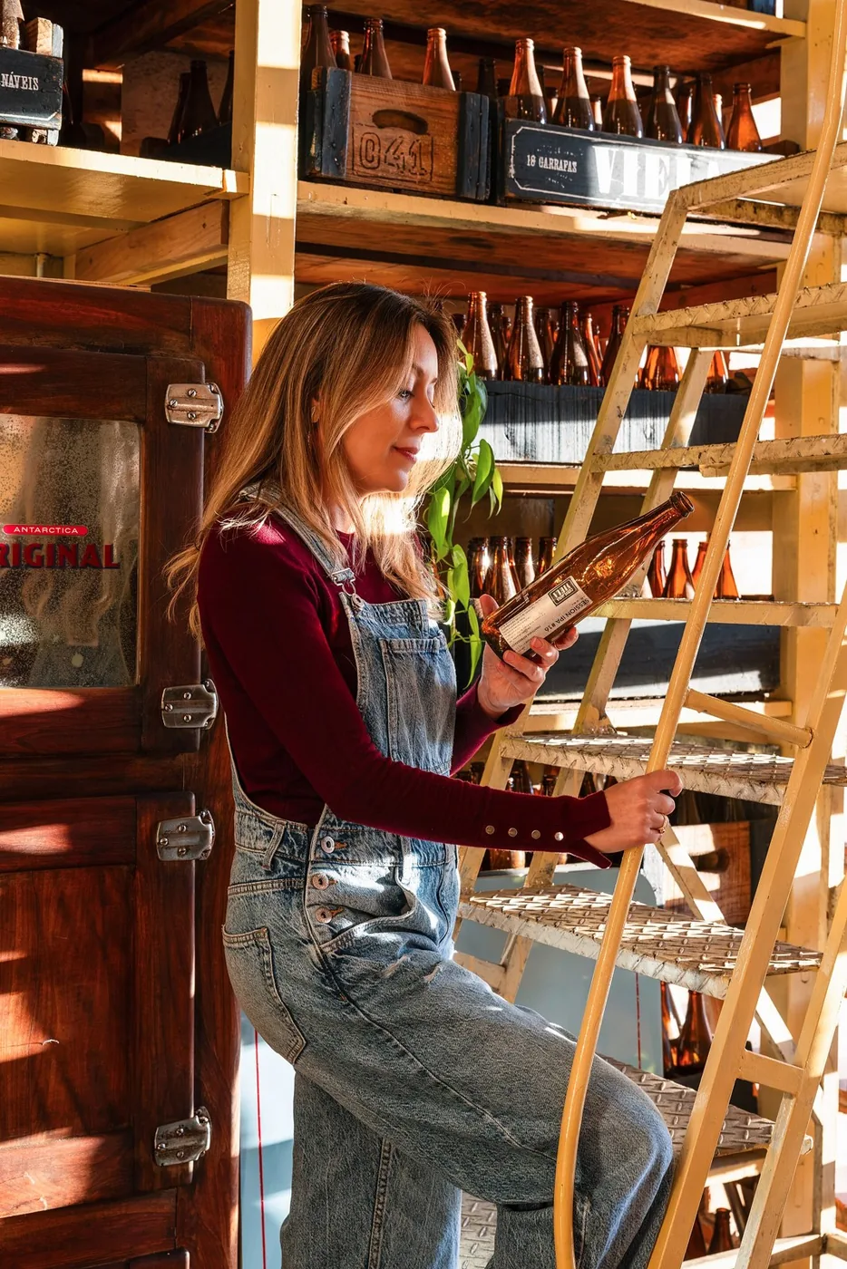 A woman beside bottle shelves in a bar at Mercado Novo, Belo Horizonte