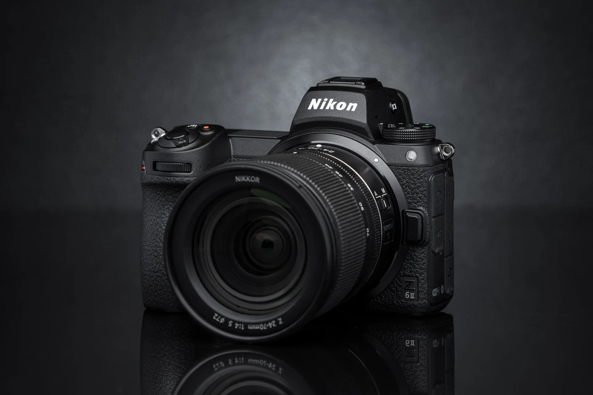 A black Nikon Z6 II with a NIKKOR Z 24-70mm f/4 S zoom lens on a dark background